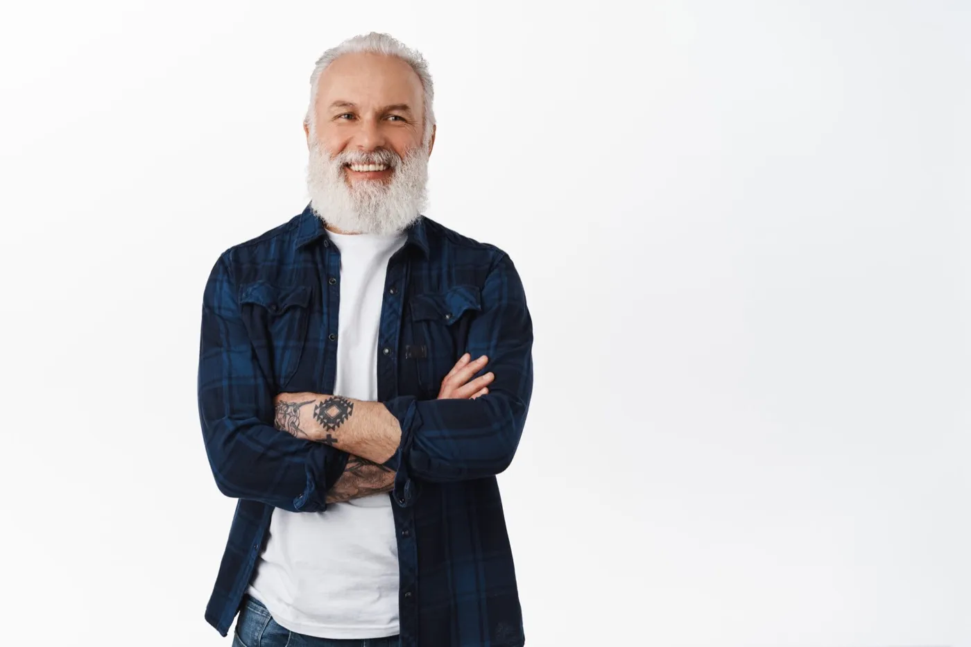 A smiling older man with a white beard and his arms folded