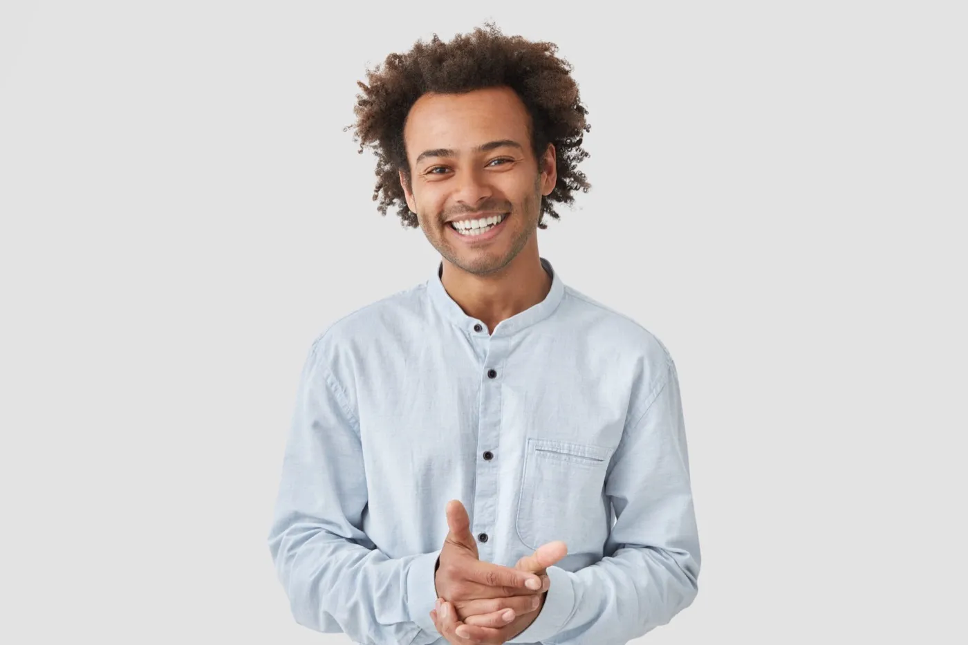 A smiling young man in a light blue shirt