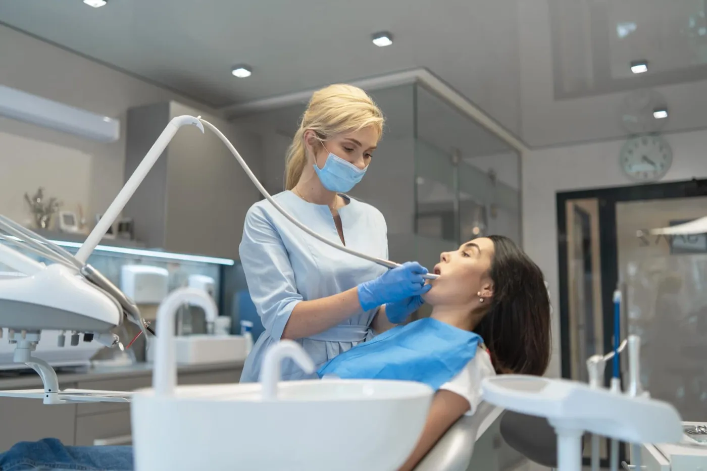 A dentist treating a woman in a modern treatment room