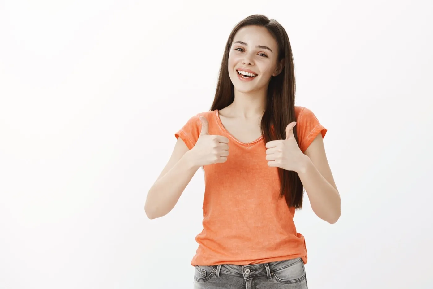 A smiling young woman giving two thumbs up
