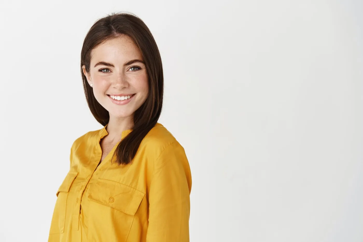 A smiling woman in a yellow shirt