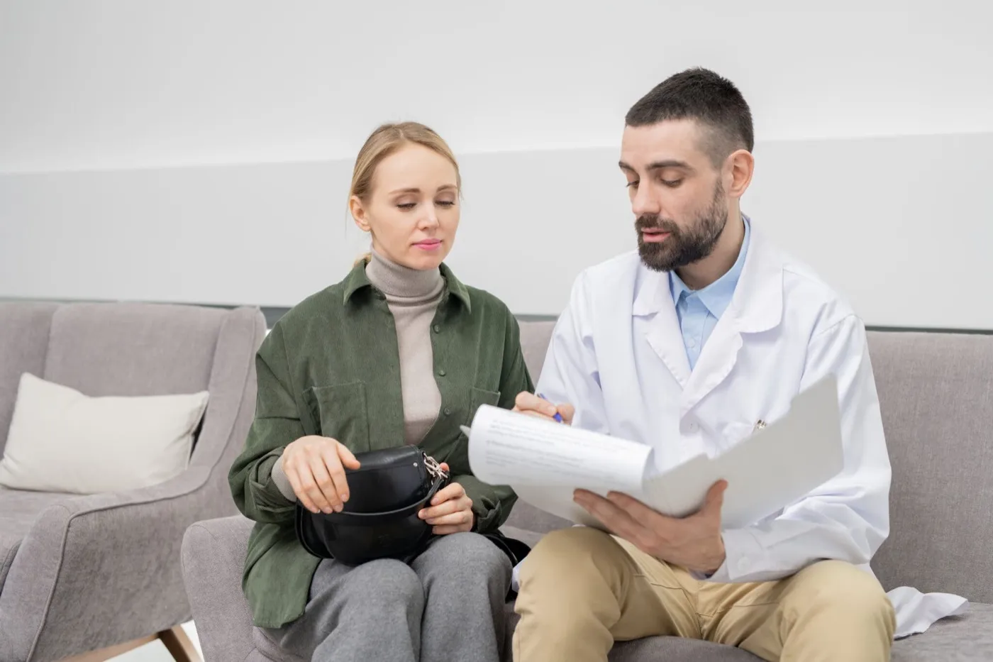 A dentist going through a document with a woman in a waiting area
