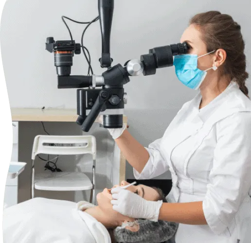 A dentist using a surgical microscope during treatment