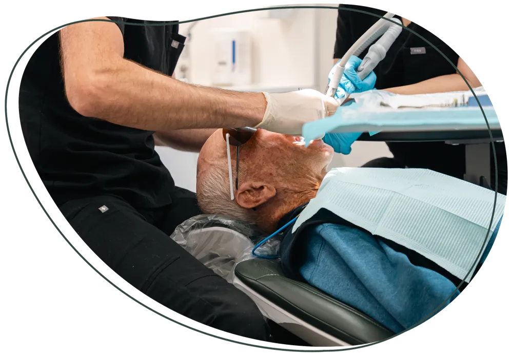 A dentist treating a patient reclined in the dental chair