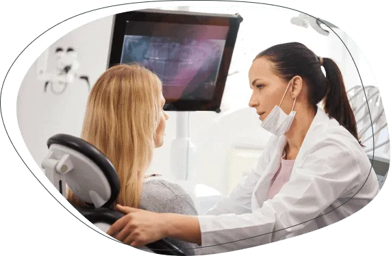 A dentist showing a patient an X-ray on a screen