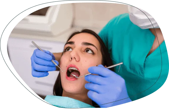 A dentist examining a young woman's braces