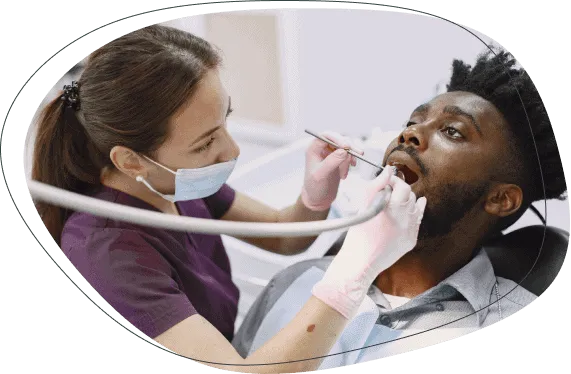 A dentist examining a man's teeth with a dental mirror