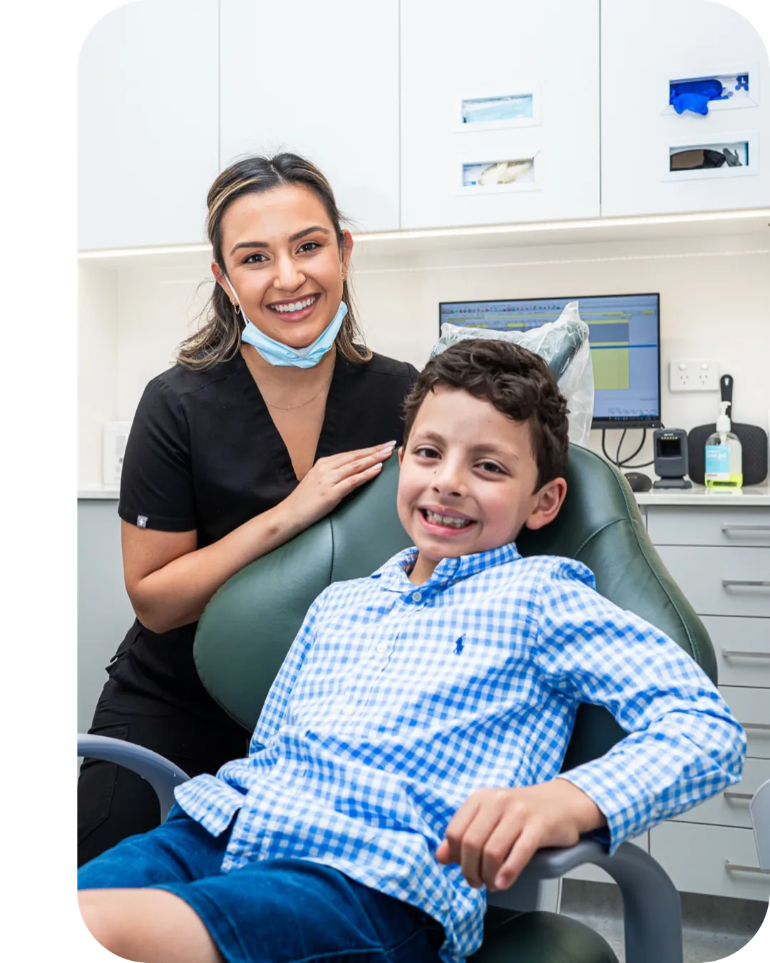 An oral health therapist with a smiling young patient in the dental chair